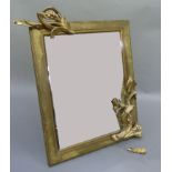 A gilt table mirror, the rectangular frame applied with scrolling leafage and blossom, the