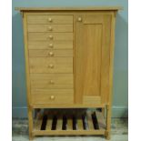 A modern pale oak cabinet fitted with eight graduated drawers flanked to the right by a single