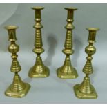 A pair of Victorian brass candlesticks of ribbed design on square bases, 30.5cm high and a similar