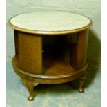 An oak bookshelf, circular top with inset glass the deep frieze segmented for books on squat