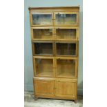 An oak five tier sectional book case having four graduated pairs of glazed doors above a two door