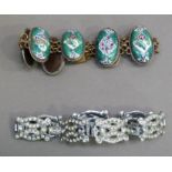 A base metal and enamelled panel bracelet each oval panel painted alternating amongst blossom
