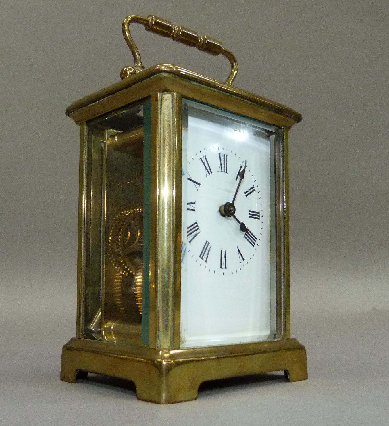 A brass carriage clock with key, white enamelled dial with black Roman numerals, 15cm overhandles