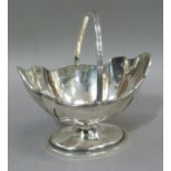 A sugar boat with reeded swing handle and rim on a circular pedestal foot, London 1894,