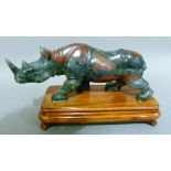 A soapstone carving of a rhinoceros, on mahogany stand 21cm wide x 12cm high