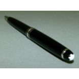 A Montblanc ball point pen in black and white metal case