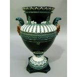 A Continental pottery majolica two handled vase of urn form with pair of bearded mask handles, the