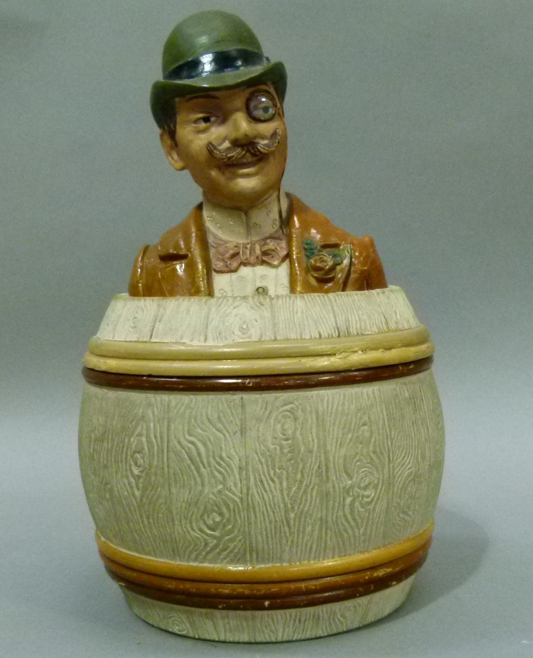 An 19th century Austrian pottery tobacco jar and cover modelled as a gentleman in elegant attire,