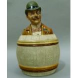 An 19th century Austrian pottery tobacco jar and cover modelled as a gentleman in elegant attire,