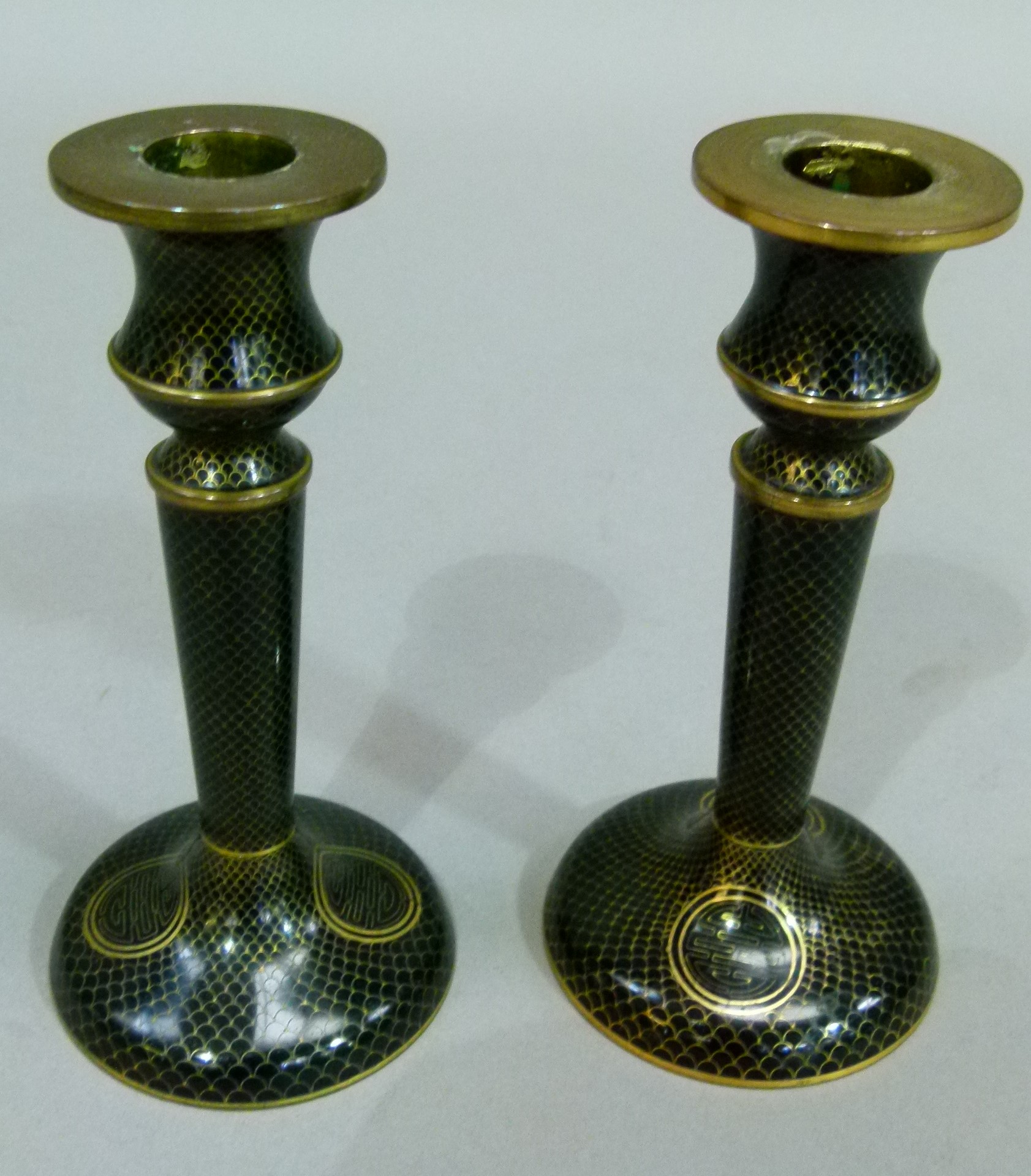 A pair of black ground cloisonne candlesticks, 14.5cm high