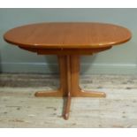 An modern extending dining table on a centre column and four legs and cruciform base, scratch to the