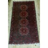 A Bokhara style rug of wine, dark blue and ivory, 203cm x 99cm