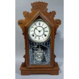 An Ansonia mantel clock with decorated glass door and carved case, 49cm high