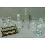 Four cut and press moulded decanters and stoppers; together with a reproduction leather bound