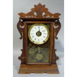 A Seth Thomas Clock Co mantel clock in a carved and stained case with gilt decorated glass door,