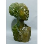 A carved head and shoulder bust of an African woman carved in hardstone, 34cm