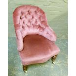A Victorian button back upholstered armchair with serpentine seat and back upholstered in pink