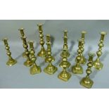 A collection of Victorian brass candlesticks of baluster ribbed design various sizes (14)