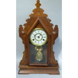 A New Haven 8 day mantel clock in a carved and stained case, 58cm high