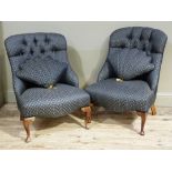A pair of upholstered button back chairs on cabriole legs with shell shaped cushions