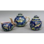 A late 19th century majolica three piece tea service moulded with fish and coral on a blue ground,