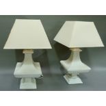 A pair of cream painted terracotta table lamps with cream cotton shades, 64cm high overall