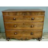A 19th century mahogany chest of three graduated drawers with deep scroll apron and on turned legs