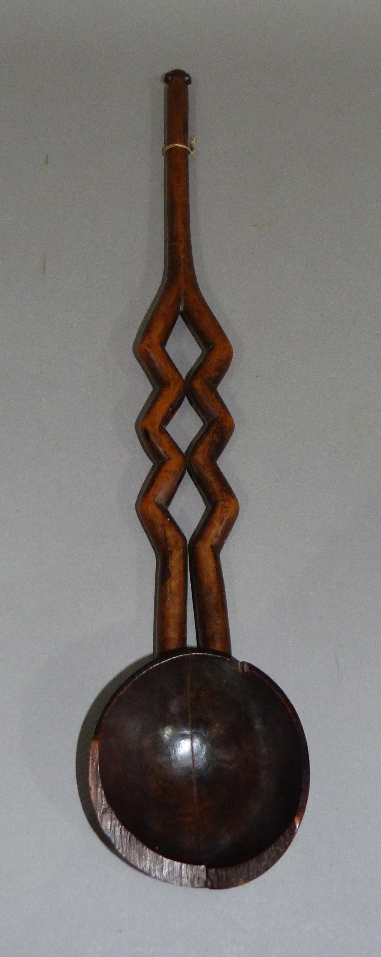 A treen ladle with open work decoration, 50cm long