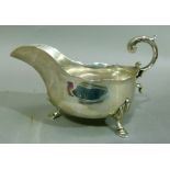 A silver sauceboat, on three hoof feet, leaf capped, scroll handle, Sheffield 1913 total approximate