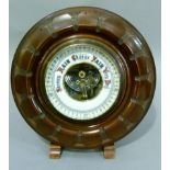 An Aneroid barometer in carved mahogany frame