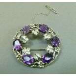 An early 20th century amethyst wreath brooch in silver the oval faceted stones claw set