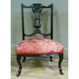 An Edwardian mahogany nursing chair having a pierced splat, upholstered seat, cabriole legs with