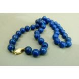 A necklace of spherical beads in stained lapis lazuli each approximately 10mm diameter,