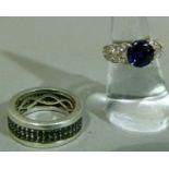 A sapphire set band ring in silver, the small circular faceted stones grain set in a double row,