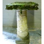 A small garden table with York stone square top supported on an ivy moulded concrete pillar, top