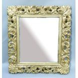 A gilt framed wall mirror the pierced surround of flowering leaf curls, 47cm x 43cm