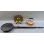 A copper kettle, a brass fleur de lys charger, copper warming pan