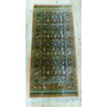 A Persian style rug having a geometric field within multiple borders in salmon, blue, green and