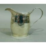 A small silver helmet cream jug with reeded rim and leaf strap handle, Chester 1900, 7.5cm high,