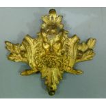 A gilt metal furniture mount cast as Pan, bearded and horned face mask within acorn and oak leaf