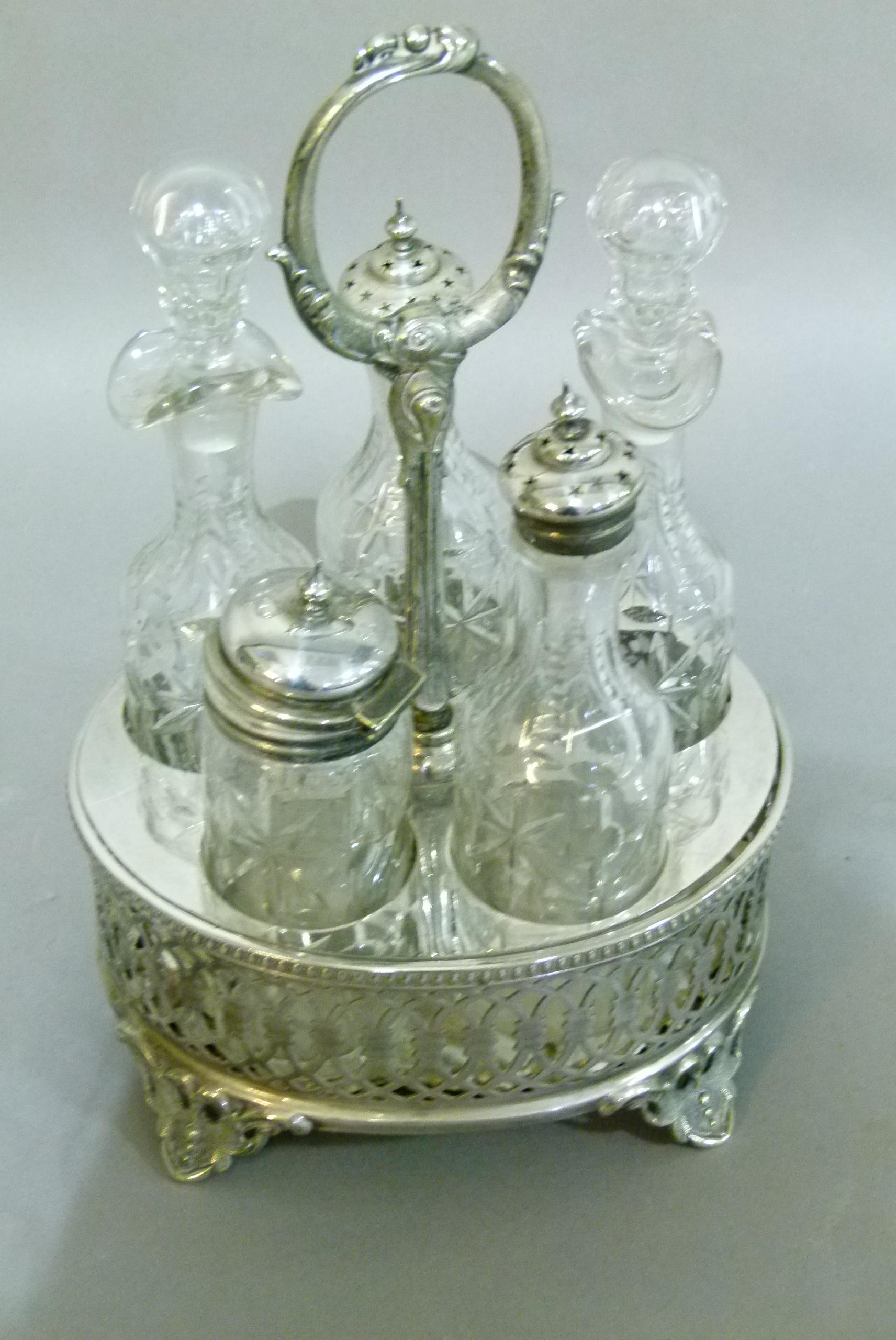 A Victorian silver plated five bottle cruet with pierced decoration and splay feet, 26cm high