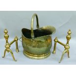 An Edwardian brass coal scuttle together with a pair of Victorian brass fire dogs (3)