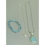 A blue topaz inline set bracelet together with a pale blue chalcedony set pendant both in silver