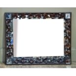 A rectangular wood framed wall mirror having a surround of carved leaves each corner inset with a