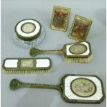 A four piece brass and ivory mounted dressing table set comprising, two brushes, mirror, powder