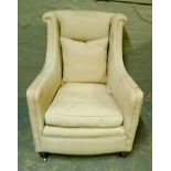 An upholstered armchair on turned legs