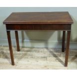 A 19th century mahogany fold over tea table on square legs