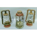 Two vintage hurricane lamps and a Tilley lamp