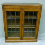 An oak bookcase with lead glazed doors, 89cm wide x 100cm high (sides cut)