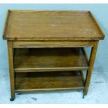 An oak folding topped trolley the rectangular top with three quarter gallery revolving and folding